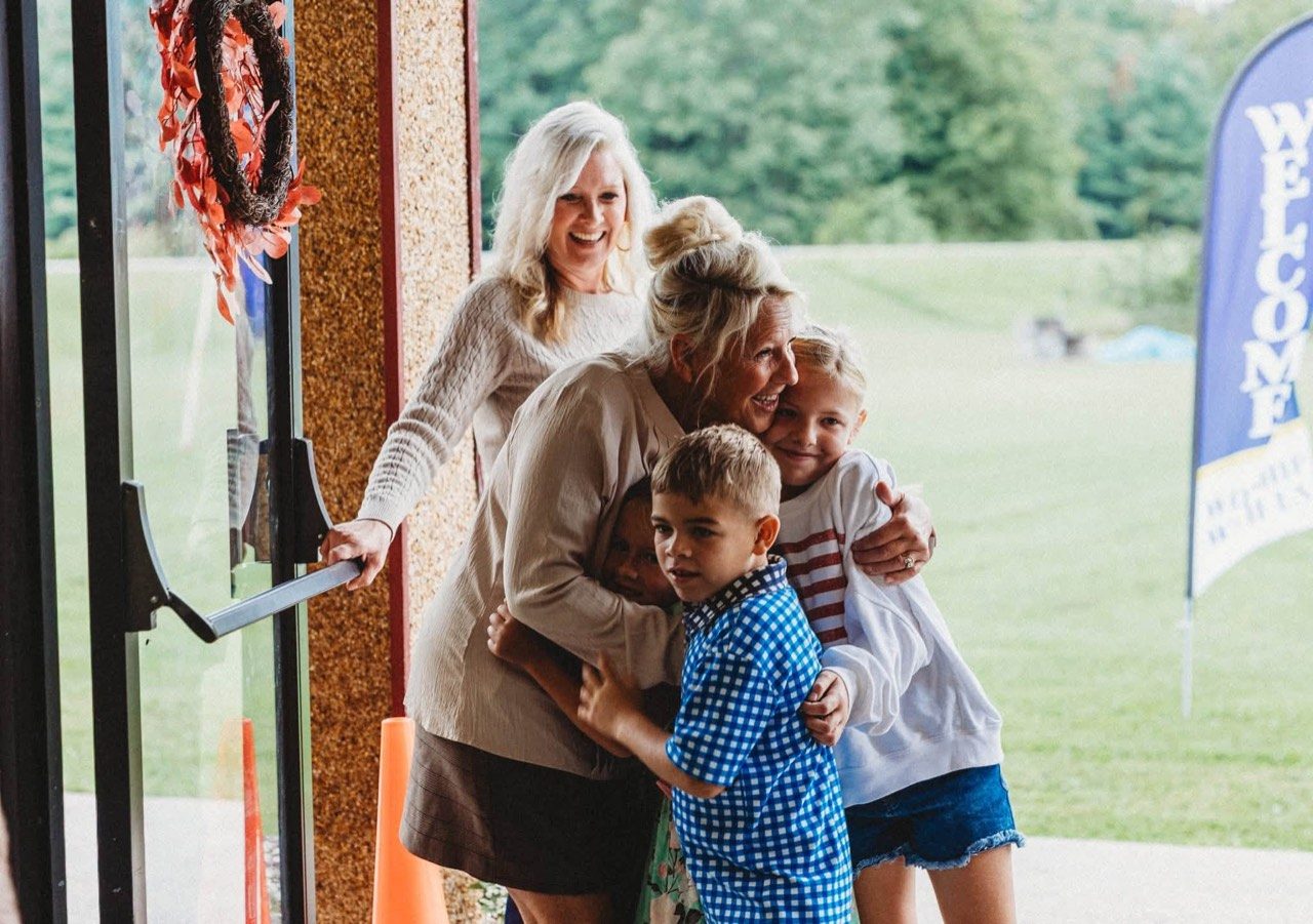 A family welcomed with hugs at the front doors of Covenant Church in Black River, NY